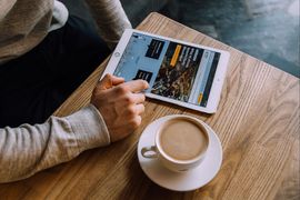 Na stole tablet z otwartą stroną rybka.rybnik.eu, obok filiżanka kawy