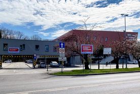 Budynek hali sportowej, na pierwszym planie czerwona tablica z napisem Rybnicki Punkt Szczepień