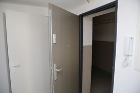 Drzwi wejściowe do nowego mieszkania, na ścianie domofon