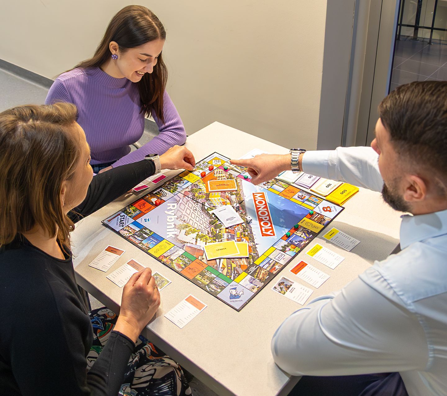 dwie kobiety oraz mężczyzna grający w Monopoly Rybnik