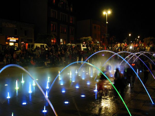 Kolorowe strumienie wody w fonntanie - zdjęcie nocne