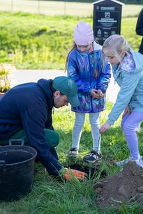 zdjęcie przedtawia dzieci sadzące drzewa