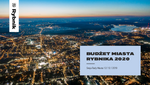 Panorama rozświetlonego miasta, z napisem Rybnik oraz informacją o budżecie miasta. 