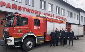 zdjęcie strażaków na tle wozu strażackiego