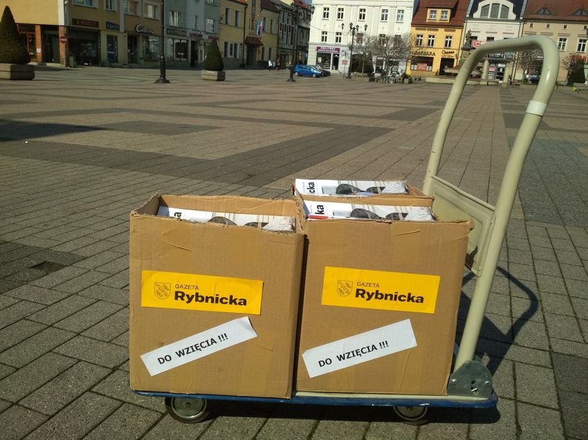 GR do wziecia fot.W.Troszka 4 Dwa kartony z egzemplarzami Gazety Rybnickiej stojące na ręcznym wózku, w tle rynek