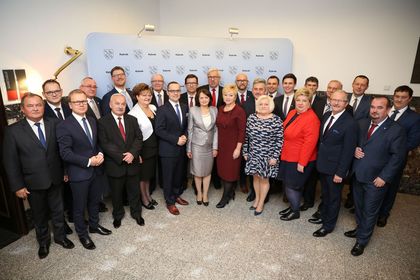 Grupa kobiet i mężczyzn stojących w pólkolu