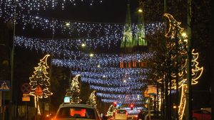 Wieczór. Świątecznie udekorowane miasto - lampki nad ulicami, choinki, i inne ozdoby.