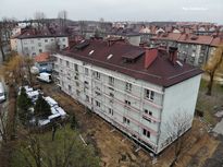 Kilkupiętrowy budynek mieszkalny po termomodernizacji. Widok z lotu ptaka.
