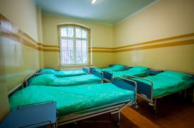 Wnetrze sali szpitalnej: łózka wzdłuż ścian