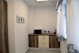 Przedpokój, jasne wnętrza, ciemne drzwi, komoda. 