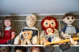 Zdjęcie przedstawia straszne lalki na półce.