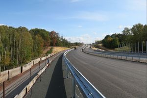 Nowo wybudowana droga, po obu jej stronach drzewa