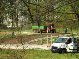 Dwa samochody służb zieleni miejskiej na ternie parku