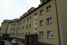 Budynek mieszkalny o jasnej elewacji. W tle niebo.