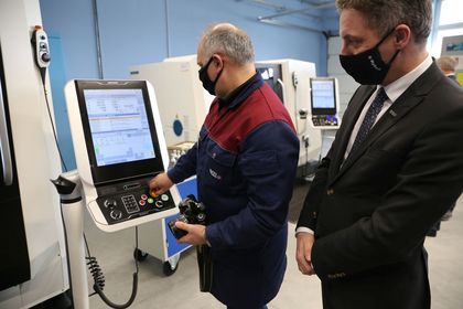 Dwóch mężczyzn testujących sprzęt elektroniczny w nowocześnie wyposażonej pracowni kształcenia zawodowego 