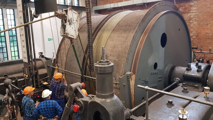 Wnętrze zabytkowej kopalni - prace przy bębnie z liną wyciągową łączącą maszynę parową z szybem kopalnianym