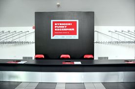 Blat, na którym wisi czerwona tablica z napisem Rybnicki Punkt Szczepień