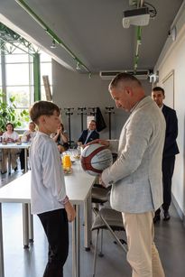 Zdjęcie przedstawia mężczyznę i chłopca. mężczyzna trzyma piłkę. 