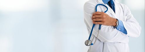 Osoba w białym fartuchu, trzymająca lekarski stetoskop