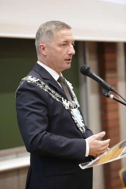 Mężczyzna przemawiający do mikrofonu.