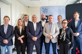 Zdjęcie przedstawia urzędników oraz pracowników firmy budowlanej