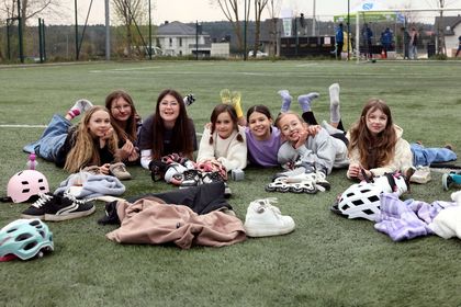 Grono dziewczynek leżące na trawie i pozujące do zdjęcia