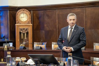 Mężczyzna przemawiający na sali sesyjnej. 