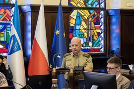 zdjęcie przedstawia półkownika przemawiającego na sesji rady