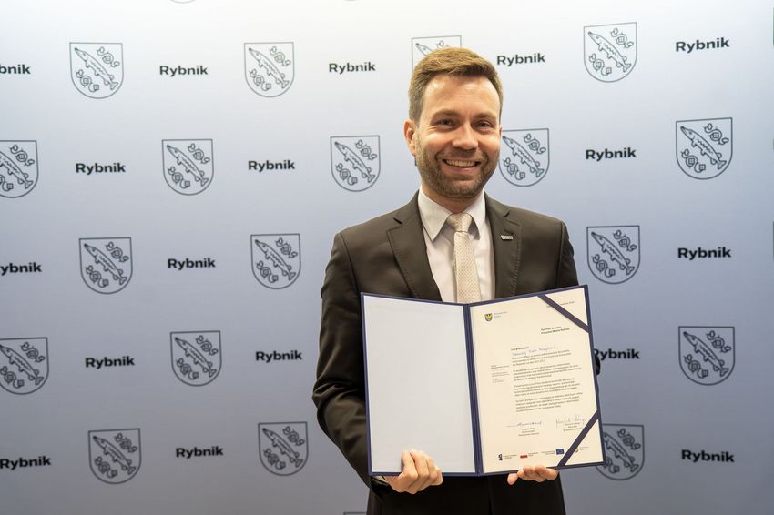 Zdjęcie przedstawia zastępcę prezydenta miasta trzymającego dyplom