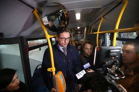 Wnętrze autobusu, w którym znajduje się kilka osób
