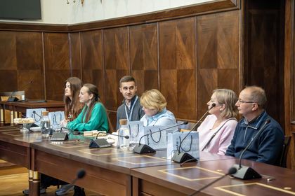 Grupa osób na sali sesyjnej podczas oficjalnego spotkania. 