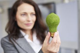 kobieta trzymająca żarówkę porośniętą roślinami