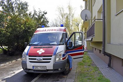 Wymazobus fot.K 1 Karetka pogotowia na podjeździe przed blokiem. Po lewej stronie zielone krzaki.