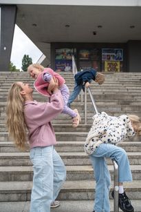 Zdjęcie przedstawia kobietę i trójkę dzieci na schodach przed rybnickim teatrem.