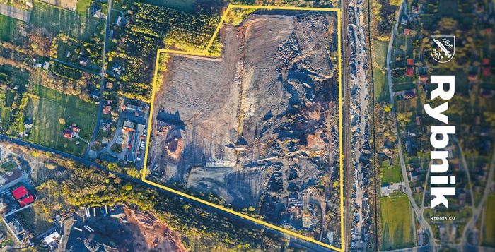 Zdjęcie terenu inwestycyjnego z lotu ptaka z obrysem działki i napisem Rybnik
