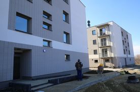 Dwa kilkupiętrowe budynki mieszkalne o jasnej elewacji