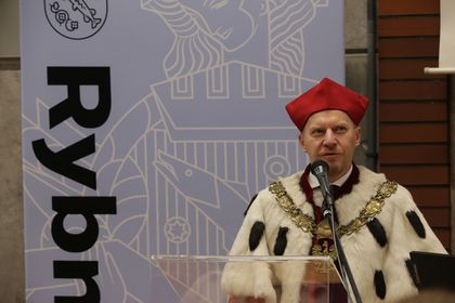Mężczyzna przemawiający do mikrofonu.