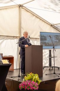 Na zdjęciu widać mężczyznę, który mówi do mikrofonu.