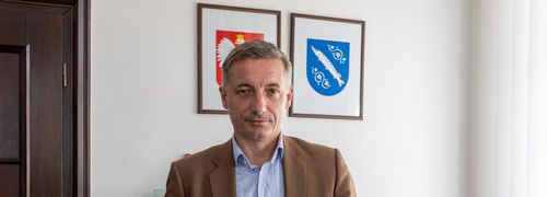 Zdjęcie przedstawia mężczyznę pozującego do zdjęcia ze statuetką.