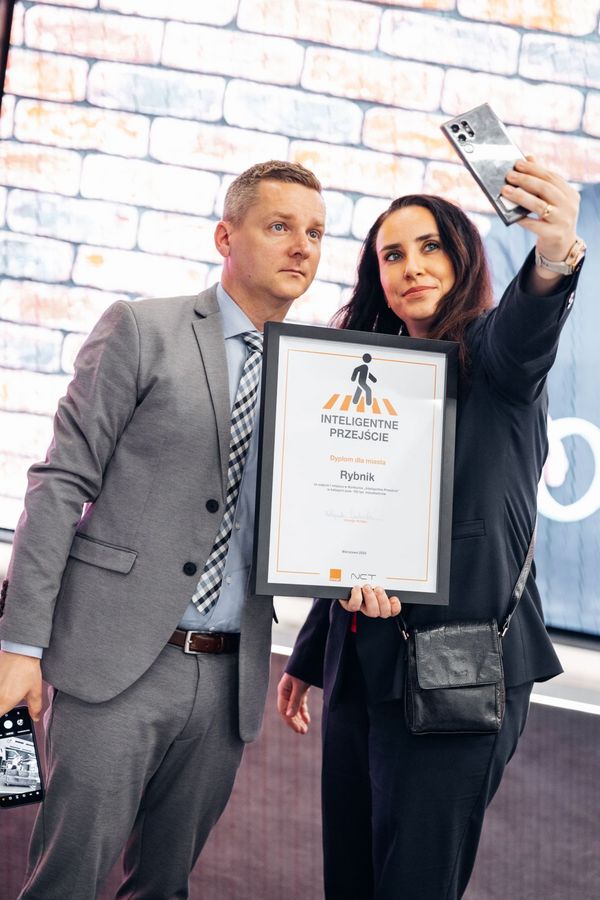 Przedstawiciele Rybnika - Ewelina Włoch, naczelniczka Wydziału Cyfryzacji i Nowych Technologii UM i Robert Cebula, Sekretarz Miasta - odbierają nagrodę dla Rybnika za "Inteliegentne Przejście"