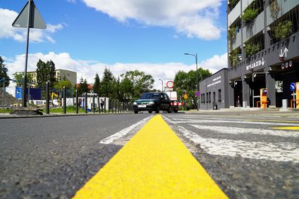 Żółta linia na drodze informująca o zmienionej organizacji ruchu w okolicach wielopoziomowego parkingu w centrum Rybnika