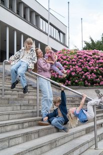 Zdjęcie przedstawia kobietę i czwórkę dzieci na schodach rybnickiego teatru.