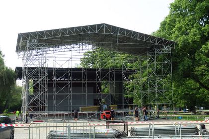 Budowa konstrukcji sceny na terenie rybnickiego kampusu. W tle zieleń i niebo.