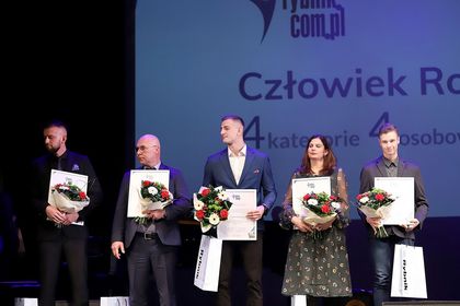 Pięć osób z kwiatami i dyplomami.