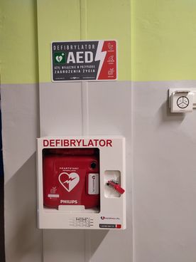 Defibrylator AED na ścianie budynku użyteczności publicznej w dzielnicy Boguszowice Osiedle. 