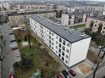 Kilkupiętrowy budynek mieszkalny po termomodernizacji. Widok z lotu ptaka.
