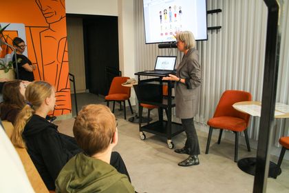 Spotkanie w Urban Labie. Jedna kobieta stoi i przemawia do reszty osób.