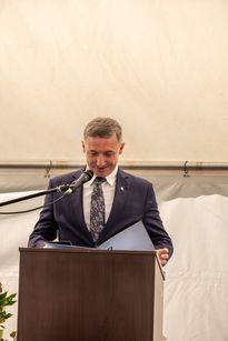 Na zdjęciu widać mężczyznę, który mówi do mikrofonu.