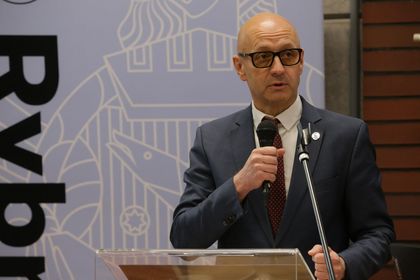 Mężczyzna przemawiający do mikrofonu. 