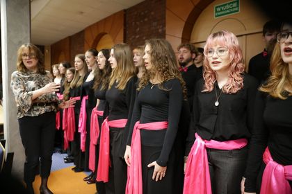 Grupa osób stojąca w auli. 